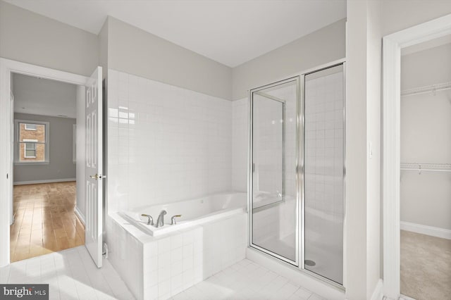 bathroom featuring plus walk in shower and wood-type flooring