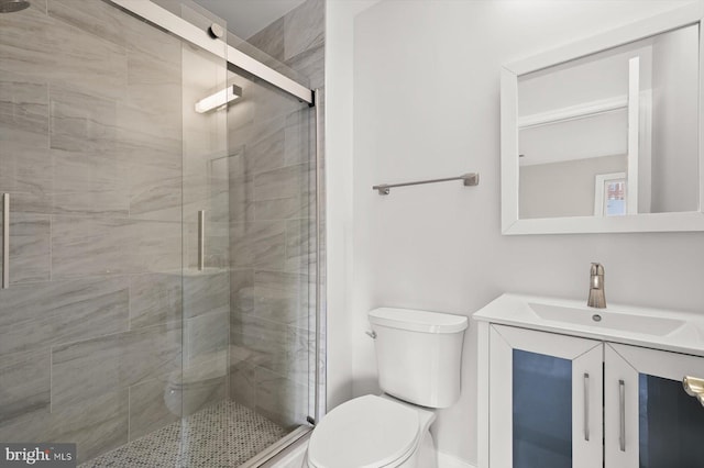 bathroom featuring walk in shower, vanity, and toilet