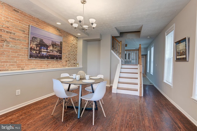 dining space featuring a chandelier, a textured ceiling, and dark wood-type flooring