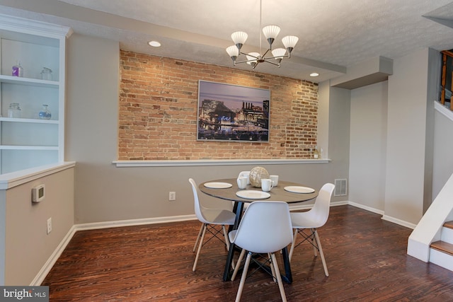 dining room featuring built in shelves, a chandelier, dark wood-type flooring, and a textured ceiling