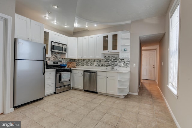 kitchen with sink, white cabinets, light tile patterned floors, and appliances with stainless steel finishes