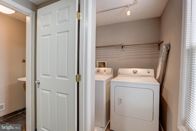 washroom featuring washer and clothes dryer and dark tile patterned flooring