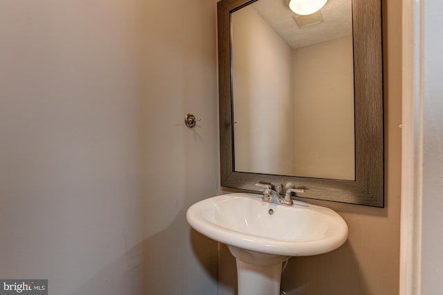 bathroom with a textured ceiling and sink