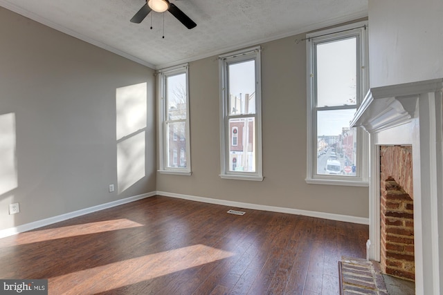 unfurnished room featuring ceiling fan, ornamental molding, a textured ceiling, and dark wood-type flooring