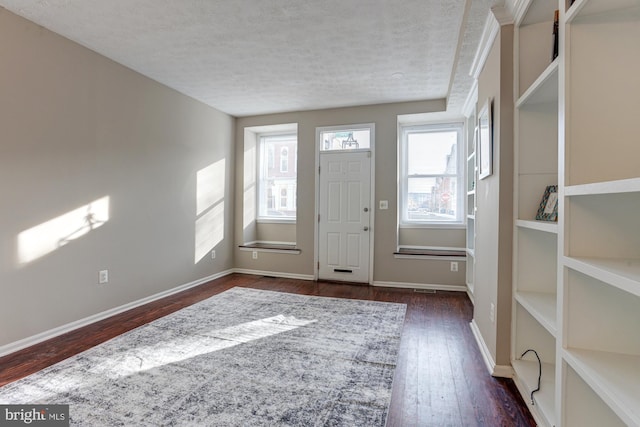 entrance foyer with a textured ceiling and dark wood-type flooring