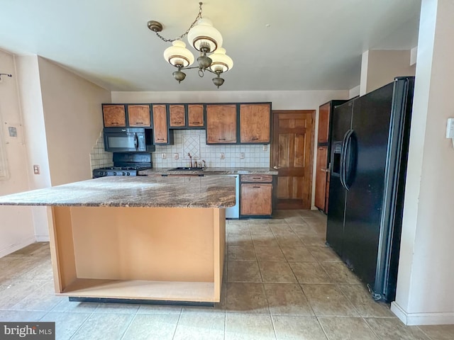 kitchen featuring sink, tasteful backsplash, a chandelier, a kitchen island, and black appliances