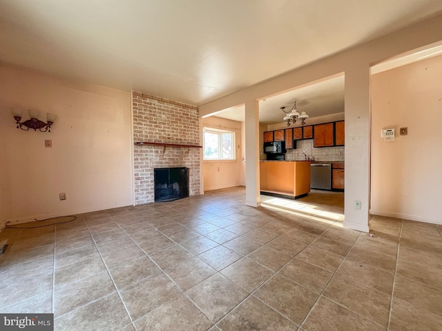 unfurnished living room featuring a fireplace, a chandelier, and tile patterned flooring