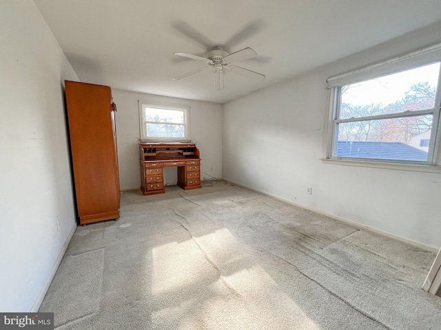 unfurnished bedroom with ceiling fan and light colored carpet