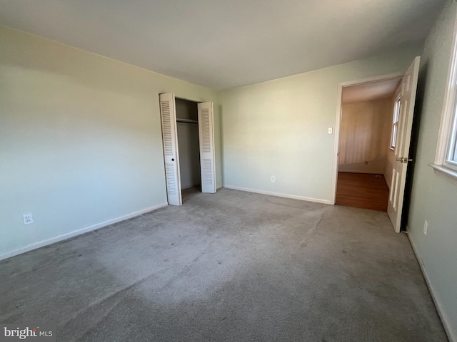 unfurnished bedroom featuring light carpet and a closet