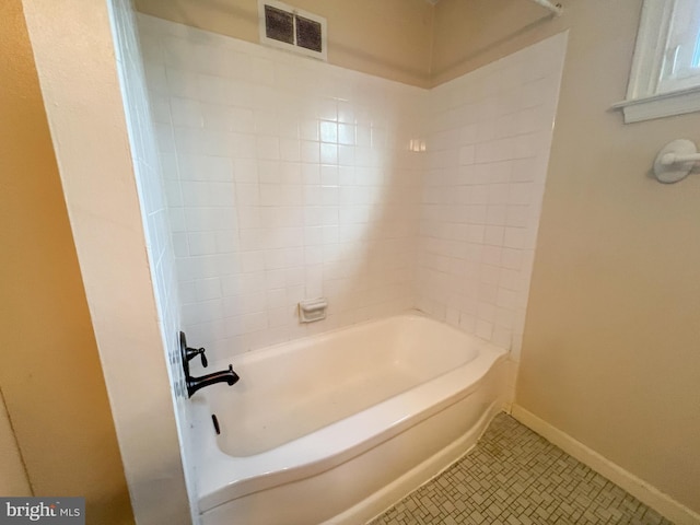 bathroom with tile patterned flooring and tiled shower / bath