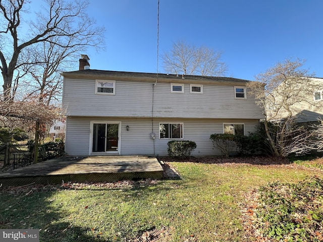 rear view of house with a deck and a yard