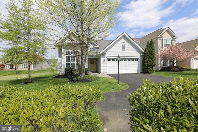 view of front of property featuring a garage and a front lawn