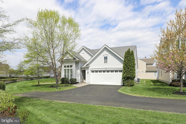 view of front of home with central AC unit, a front lawn, and a garage