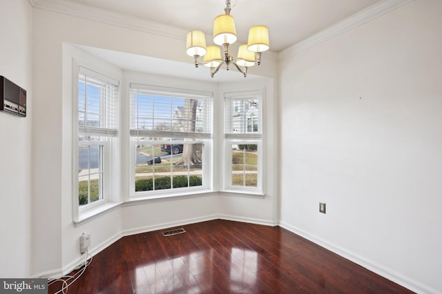 unfurnished dining area featuring a chandelier, hardwood / wood-style flooring, and crown molding