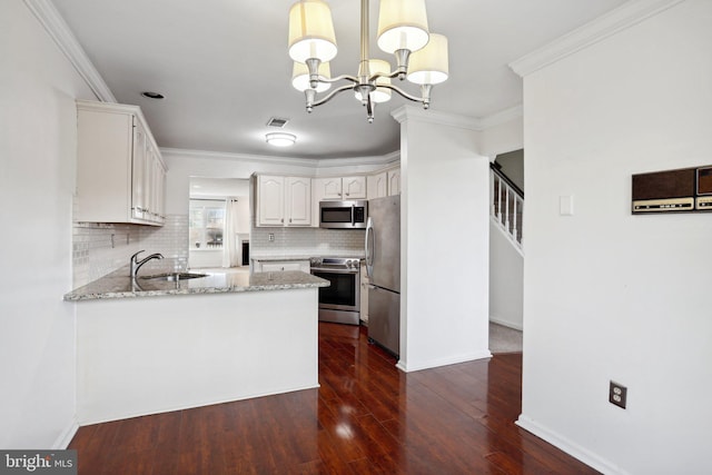 kitchen featuring white cabinetry, sink, dark hardwood / wood-style flooring, decorative light fixtures, and appliances with stainless steel finishes