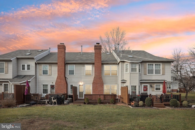 back house at dusk featuring a yard