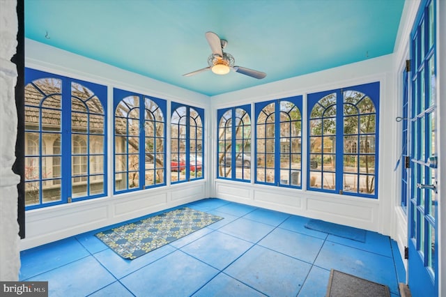 unfurnished sunroom with ceiling fan