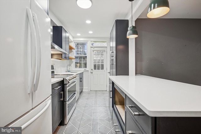 kitchen featuring sink, white refrigerator, backsplash, decorative light fixtures, and stainless steel electric stove