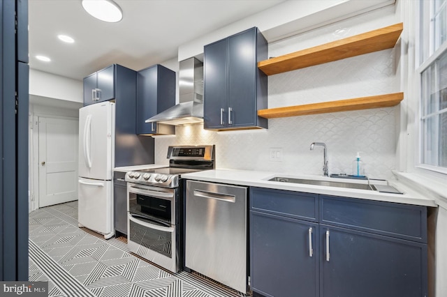 kitchen with backsplash, sink, wall chimney exhaust hood, blue cabinetry, and stainless steel appliances