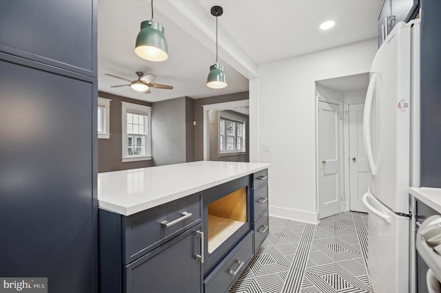 kitchen featuring pendant lighting, ceiling fan, white fridge, and dark tile patterned floors