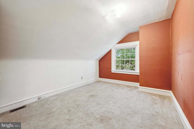 additional living space featuring carpet floors and lofted ceiling