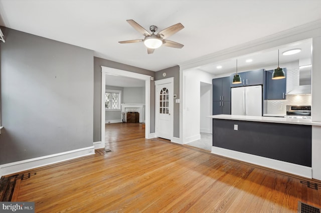 unfurnished living room with ceiling fan and light wood-type flooring