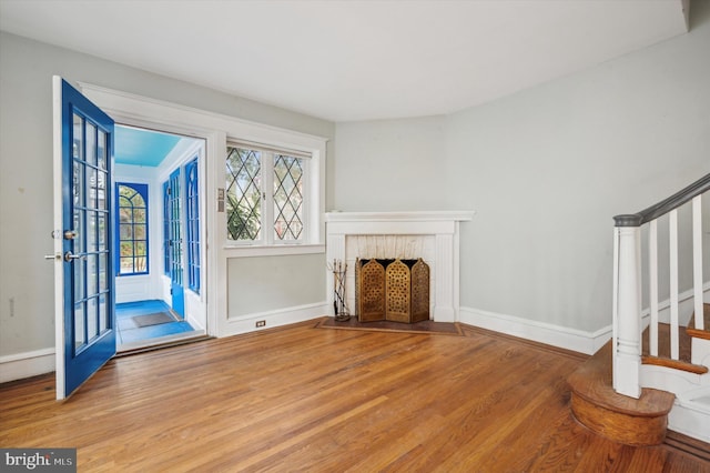 unfurnished living room featuring french doors and wood-type flooring