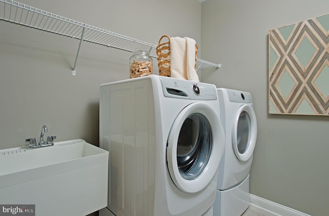 laundry area featuring washing machine and dryer and sink