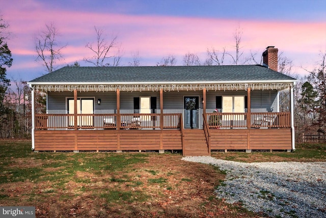 view of front facade with a porch and a lawn