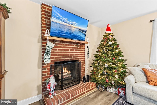 living room featuring hardwood / wood-style floors and a brick fireplace