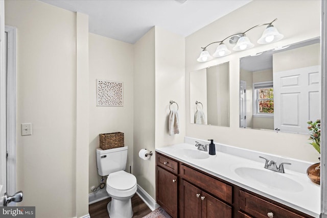 bathroom with hardwood / wood-style floors, vanity, and toilet