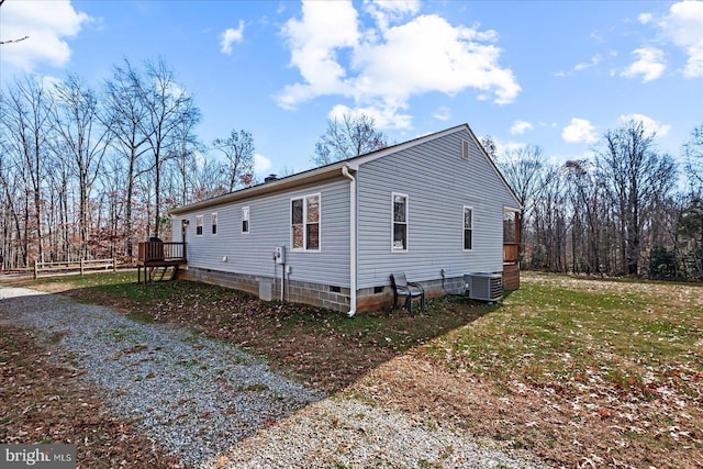 view of side of home featuring a yard and central AC unit