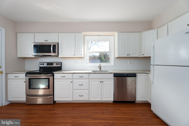 kitchen featuring white cabinetry, sink, stainless steel appliances, light stone counters, and dark hardwood / wood-style floors