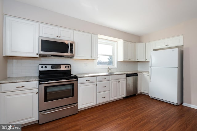 kitchen featuring light stone countertops, stainless steel appliances, sink, white cabinets, and dark hardwood / wood-style floors