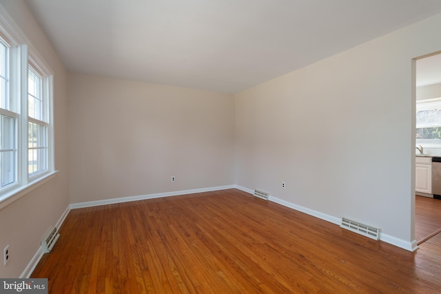 unfurnished room featuring light hardwood / wood-style floors and sink