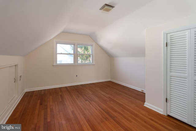 additional living space featuring hardwood / wood-style floors and lofted ceiling