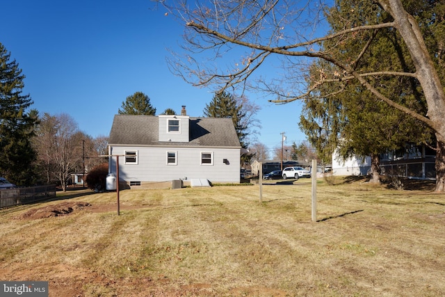 rear view of house featuring a lawn