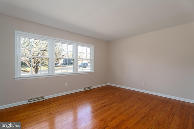 spare room with hardwood / wood-style floors and a wealth of natural light