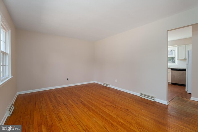 spare room with a healthy amount of sunlight and wood-type flooring