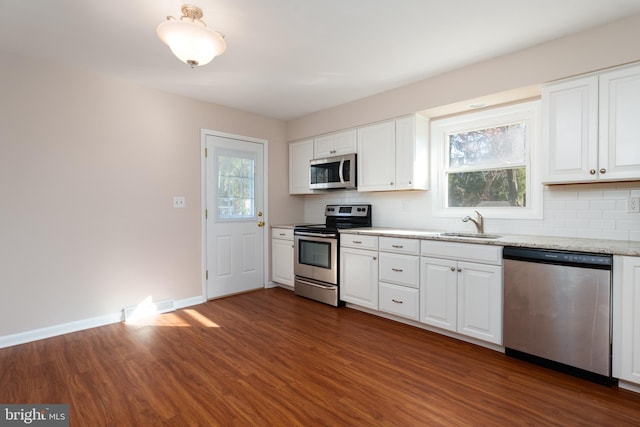 kitchen with dark hardwood / wood-style flooring, backsplash, stainless steel appliances, white cabinets, and plenty of natural light