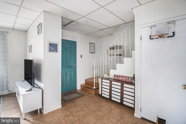 tiled foyer featuring a paneled ceiling