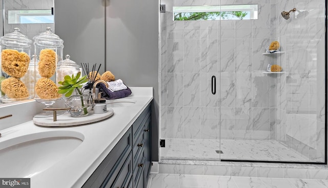 bathroom featuring a shower with door, vanity, and plenty of natural light