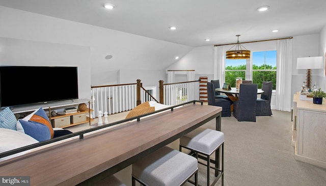 interior space with light colored carpet, an inviting chandelier, and lofted ceiling