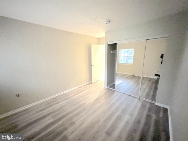 unfurnished bedroom featuring hardwood / wood-style floors and a closet