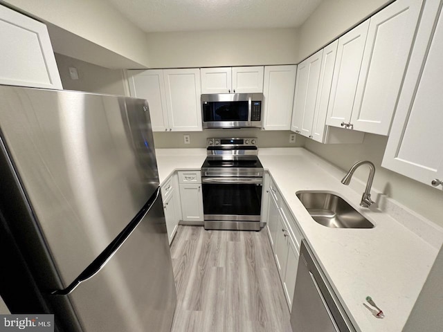 kitchen featuring sink, white cabinets, and appliances with stainless steel finishes