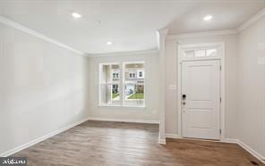 foyer entrance with hardwood / wood-style floors and crown molding