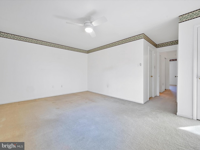 carpeted spare room featuring ceiling fan