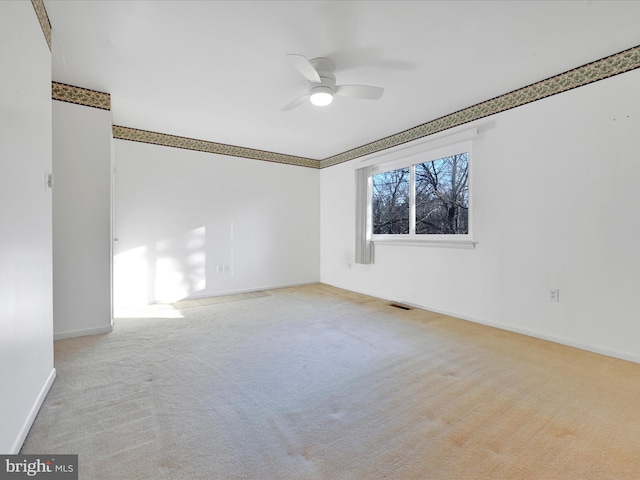 spare room featuring ceiling fan and light carpet