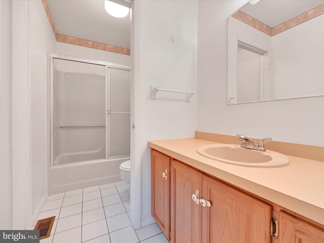 full bathroom featuring tile patterned floors, vanity, bath / shower combo with glass door, and toilet