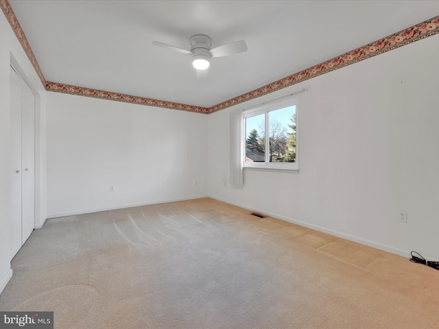 carpeted empty room featuring ceiling fan